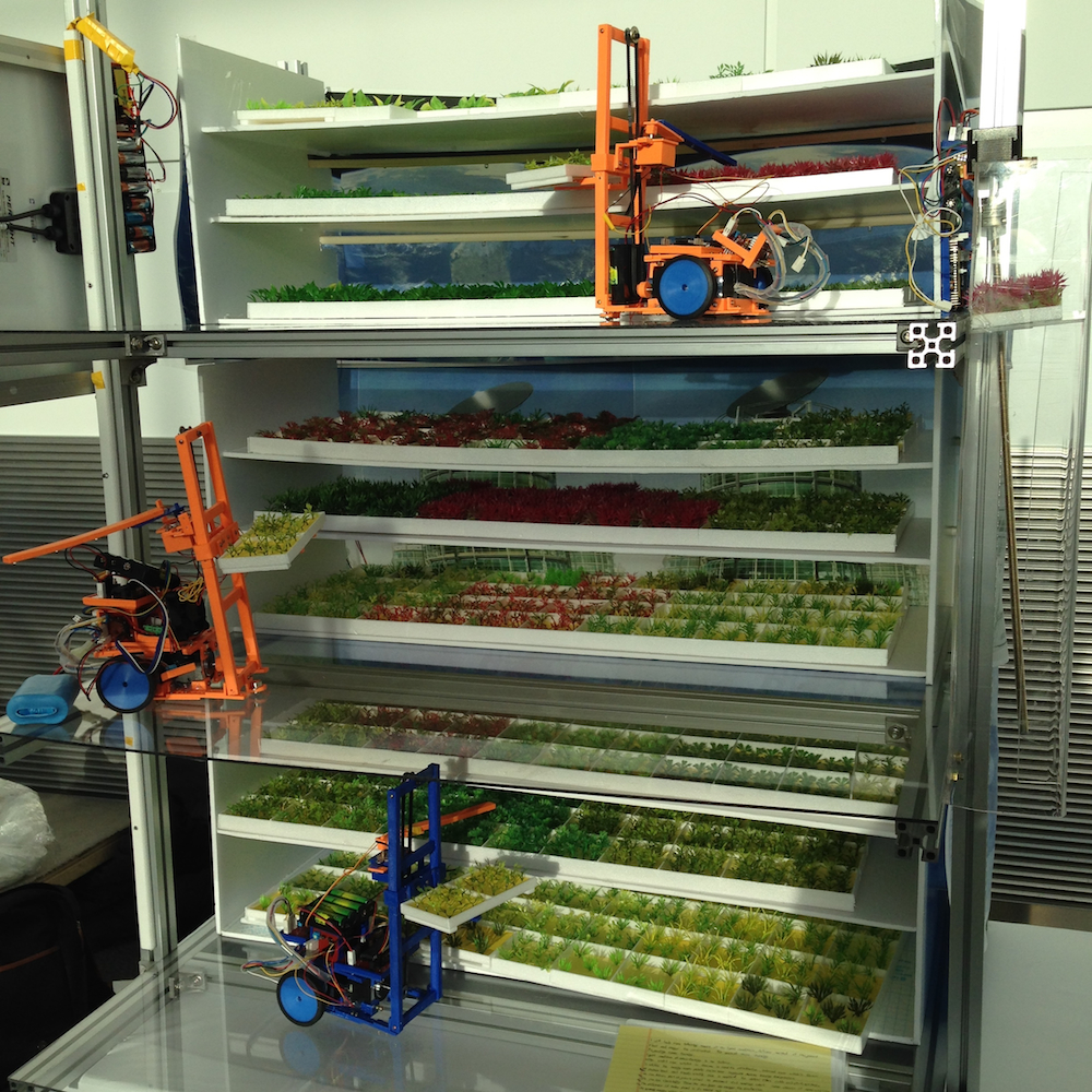 Model of multilevel plant production facility with artificial lighting and autonomous forklifts to handle trays.