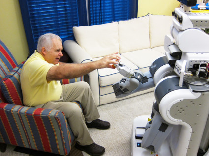 A robot hands a medication bottle to a person. Photo credit: Keith Bujak. Source: Georgia Tech News Center 