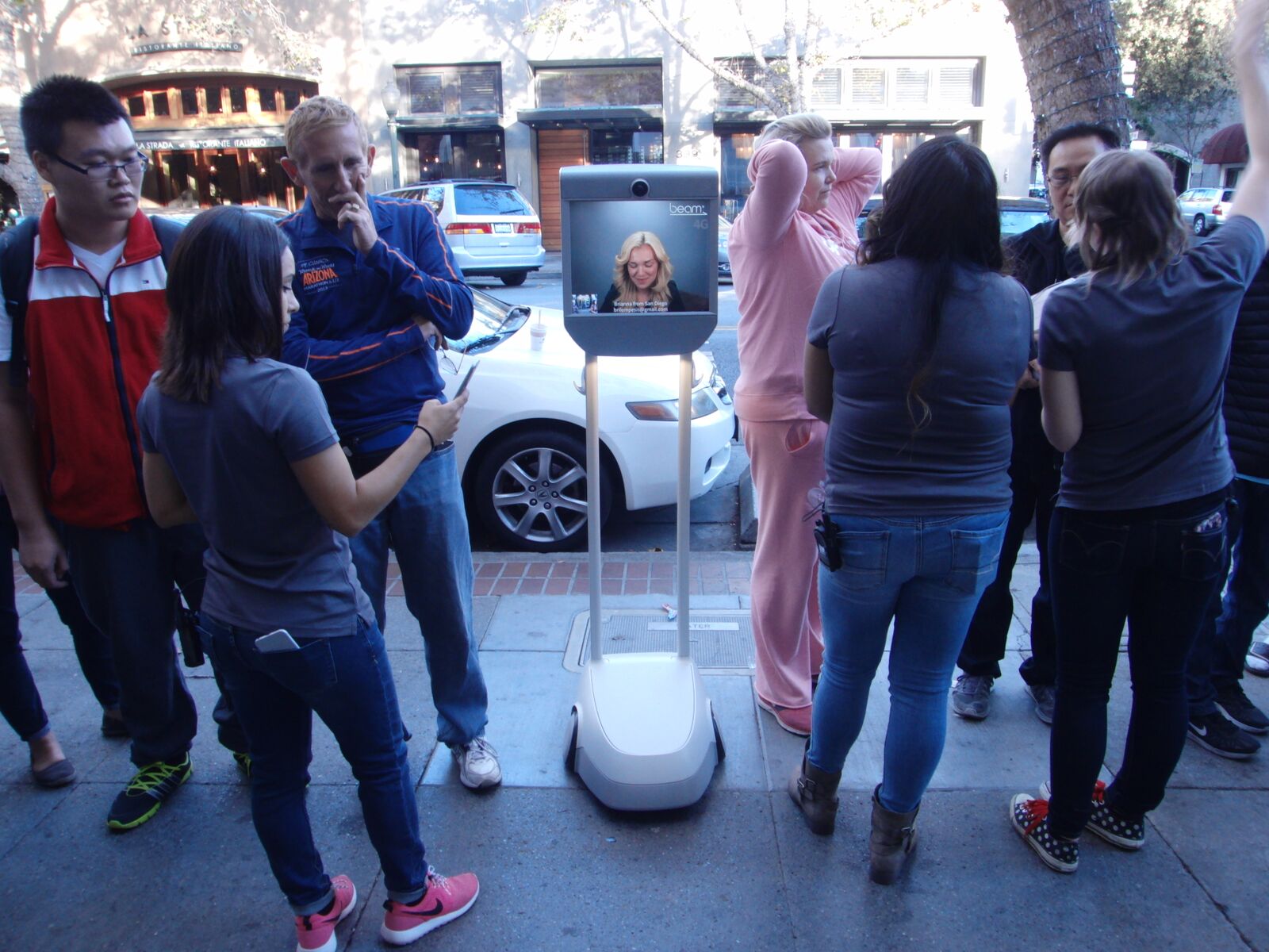 Using a BeamPro, Brianna Lempesis waits in line to buy an iPhone6s from the Apple Store in downtown Palo Alto. Photo: Suitable Technologies.