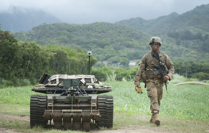 A U.S. Army Pacific Soldier moves down a road while controlling an unmanned vehicle as part of the Pacific Manned Unmanned – Initiative July 22, 2016, at Marine Corps Training Area Bellows, Hawaii. PACMAN-I provided an opportunity for Soldiers, partnered with organizations and agencies such as the Maneuver Center of Excellence and the U.S. Army Tank Automotive Research Development and Engineering Center, to test new technology in the field during practical exercises. (U.S. Air Force photo by Staff Sgt. Christopher Hubenthal)